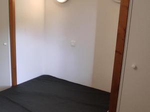 une petite chambre avec un lit et un miroir dans l'établissement Appartement 4 pers. avec balcon au calme, accès piscine - FR-1-814-167, à Vassivière