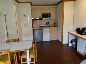 une petite cuisine avec une table et une salle à manger dans l'établissement Appartement cosy 4 pers. – Balcon, parking - FR-1-814-166, à Chastreix 8 autres photos