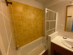 une salle de bain avec une baignoire, un lavabo et une douche dans l'établissement Appartement cosy 4 pers. – Balcon, parking - FR-1-814-166, à Chastreix