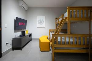a living room with a loft bed and a television at 113-Studio Amplo e completo com ar condicionado prox UEL in Londrina