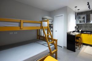 a room with two bunk beds and a kitchen at 113-Studio Amplo e completo com ar condicionado prox UEL in Londrina