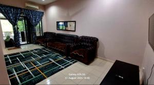 a living room with leather couches and a rug at Homestay Kuala Berang Solehah Full Aircond Wifi & Netflix in Kuala Berang