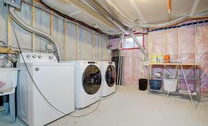 a laundry room with two washing machines in it at Downsview Park Luxury Townhome near Yorkdale Transit in Toronto