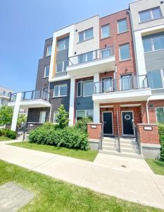 an apartment building with a sidewalk in front of it at Downsview Park Luxury Townhome near Yorkdale Transit in Toronto