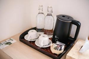 a tray with a coffee maker and bottles on a counter at Srikrisna in Seminyak