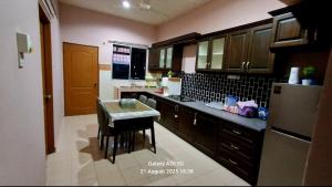 a kitchen with a small table and a refrigerator at Homestay Kuala Berang Solehah Full Aircond Wifi & Netflix in Kuala Berang