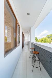 a hallway with two stools and a wall with windows at Srikrisna in Seminyak