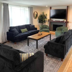 un salon avec des canapés, une table et une télévision dans l'établissement Happy Place, à South Jordan