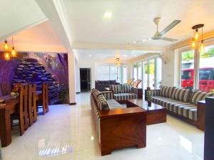 een grote woonkamer met banken en een tafel bij White lotus villa in Ragama