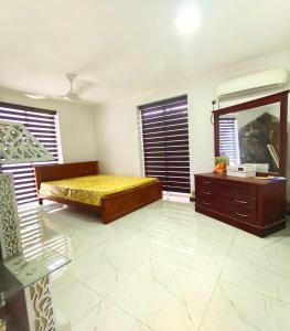 een slaapkamer met een bed, een dressoir en ramen bij White lotus villa in Ragama