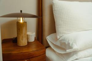 een lamp op een houten tafel naast een bed bij The Luxe Haven at BGC in Sampong
