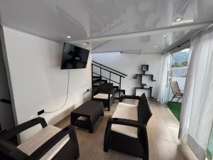 a living room with chairs and a tv on the wall at Apartamentos FM 401 in Líbano +18 photos
