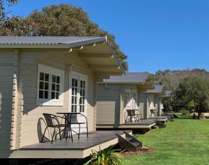 a row of houses with chairs on a deck at Griffith Caravan Village in Yoogali