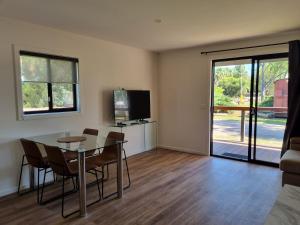 a dining room with a table and chairs and a television at Griffith Caravan Village in Yoogali