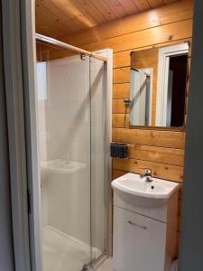a bathroom with a shower and a sink and a mirror at Griffith Caravan Village in Yoogali +14 photos