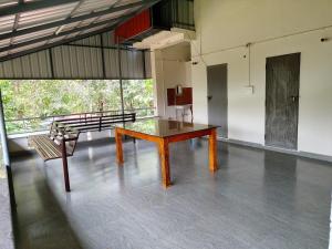 a room with a table and a bench in a building at whisperingstrem's RIVER view homestay in Padinjarathara