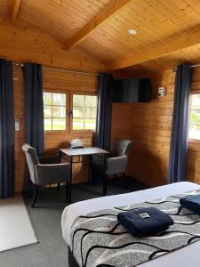 a bedroom with a bed and a table and chairs at Griffith Caravan Village in Yoogali