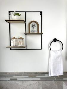une salle de bains avec des étagères noires et une serviette dans l'établissement Happy Place, à South Jordan