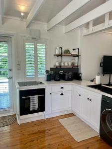 a kitchen with white cabinets and a stove top oven at The Stables in Armidale