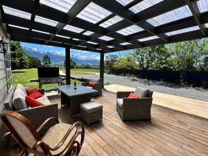 a patio with chairs and a table on a wooden deck at Kaikōura Mountain View Lodge in Kaikoura