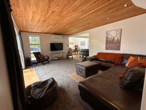 a living room with a couch and a tv at Kaikōura Mountain View Lodge in Kaikoura