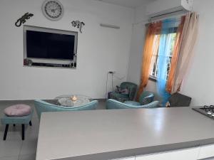 a living room with blue chairs and a flat screen tv at Happy Place in Tel Aviv