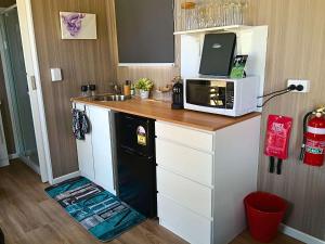 a kitchen with a microwave and a sink at Kalmya Farm Retreat by Tiny Away in Nanango
