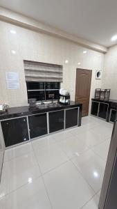 a large kitchen with a large white tiled floor at Homestay Sri Aman in Simanggang