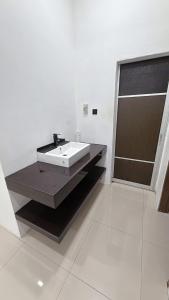 a white bathroom with a sink and a shower at Homestay Sri Aman in Simanggang