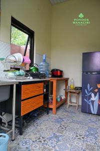 a kitchen with a counter and a sink and a refrigerator at Pondok Wanagiri in Gitgit