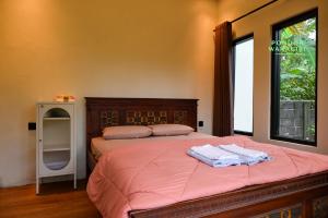a bedroom with a bed with two towels on it at Pondok Wanagiri in Gitgit