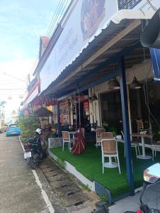 a store with chairs and a motorcycle parked in front of it at Mt Olympus Retreat Hotel in Mae Nam