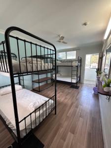 a room with two bunk beds and a wooden floor at Seaside Lodge Hostel Townsville- right next to coles, 2 mins walk to strand & CBD- Passport required in Townsville +36 photos