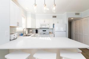 a white kitchen with white appliances and white cabinets at Coast is Clear- Oceanfront Escape at Topsail Dunes in North Topsail Beach