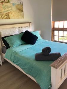 a bedroom with a bed with a green comforter at Captains Cottage - Pet Friendly Breakfast Included in Goolwa