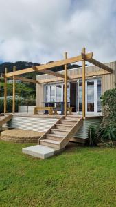 ein Haus mit einer großen Terrasse mit Veranda in der Unterkunft Beach Break in Ahipara