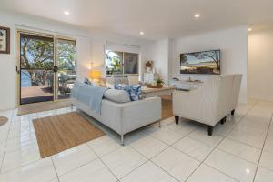 a living room with a couch and two chairs at Luminara Luxury Lakefront in Smiths Lake