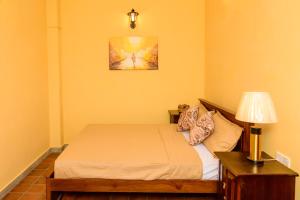 a bedroom with a bed and a lamp on a table at Villa302 in Galle +55 photos