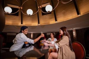 ペタリンジャヤにあるPaxtonz Leisure Suites Kuala Lumpurのバーの周りに座って飲み物を飲んでいる人々のグループ