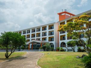 a large white building with a red roof at Whinstone Hotel & Resort in Jeju