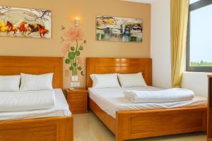 a bedroom with two beds and a window at Hostel Luxury Tây Bắc in Rạch Giá