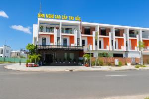 an orange and white building with a sign on it at Hostel Luxury Tây Bắc in Rạch Giá