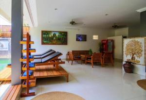 a living room with wooden furniture and a dining room at Siem Reap ABACUS Hotel in Siem Reap