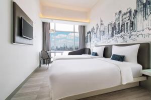 una habitación de hotel con dos camas y un televisor en YELLO Hotel Harmoni, en Yakarta 72 fotos más