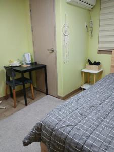 Habitación con cama, escritorio y mesa. en 전주시외버스터미널 원룸, en Jeonju