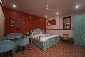 a bedroom with a bed and a table and chairs at Artistik Abode by Stay Banaras in Varanasi