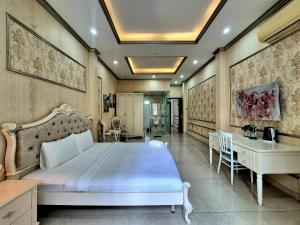 Un dormitorio con una cama blanca grande y un escritorio en F F HOUSE Homestay, en Ho Chi Minh