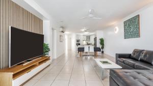 a living room with a large flat screen tv on a wall at Ocean View 3-Bedroom Apartment on the Esplanade in Cairns