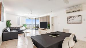a living room with a black table and a couch at Ocean View 3-Bedroom Apartment on the Esplanade in Cairns +21 photos