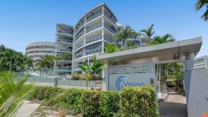 an apartment building with a parking garage in front of it at Ocean View 3-Bedroom Apartment on the Esplanade in Cairns